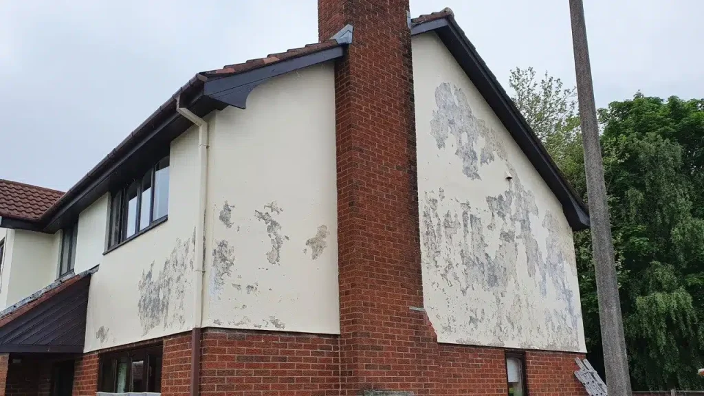 Exterior house wall showing peeling and blistering paint caused by moisture damage